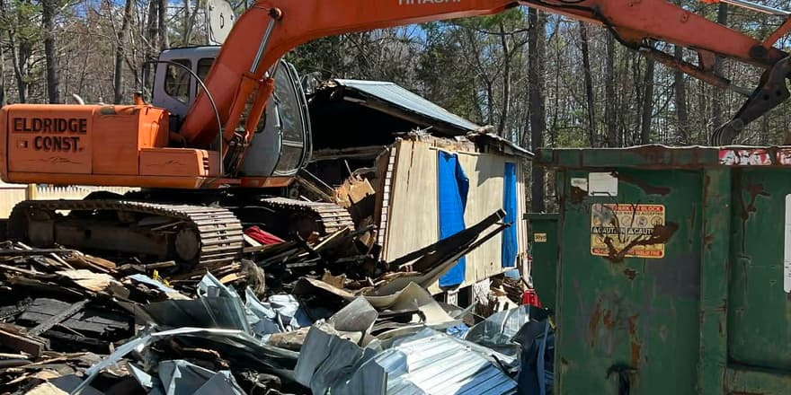 Excavator demolishing an old building